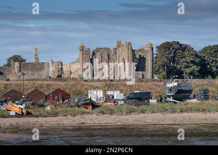 Lindisfarne, Northumberland, UK, Summer view of the ruins of the medieval Lindisfarne Priory with boats in the foreground. No people. Copy Space. Stock Photo