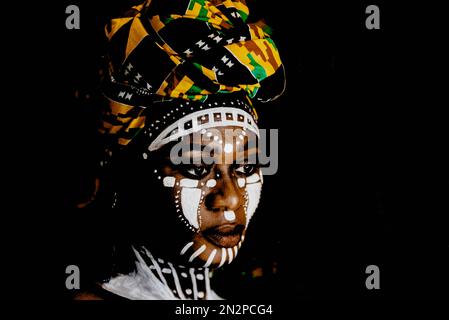 African woman in portrait with face painting and headdress. Stock Photo