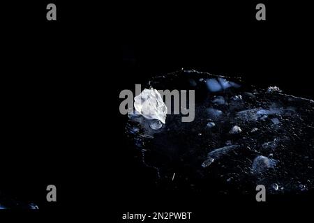 Real light piece of ice on dark water at cool winter day Stock Photo