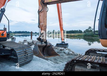 Construction machinery carrying out regulation works at the Odra river in order to adapt it to the class III waterway in Brody village. The Odra River is an important communication route, it is part of the E30 waterway connecting the Baltic Sea with the Danube in Bratislava. The E30 waterway in Poland covers the Odra River from the border with the Czech Republic to Swinoujscie, where the Swinoujscie LNG terminal is located.WWF Germany and experts from the IGB Leibniz-Institute of Freshwater Ecology and Inland Fisheries call for the cessation of works aimed at expanding the Oder riverbed and re Stock Photo