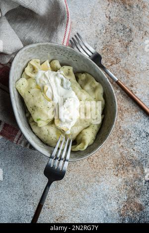 Close-up overhead view of a bowl of traditional potato Ukrainian vareniki with sour cream Stock Photo
