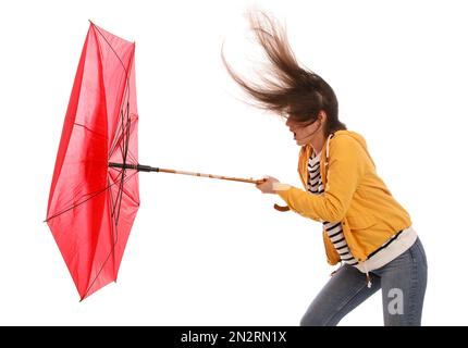 Woman with umbrella caught in gust of wind on white background Stock Photo