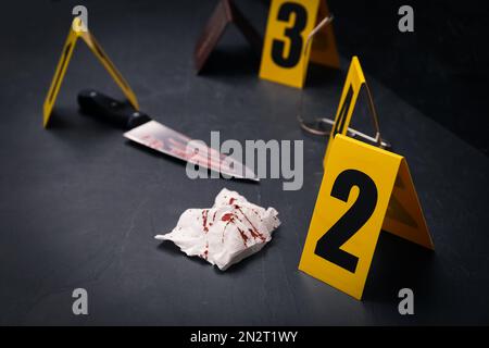Crime scene markers and evidences on black background Stock Photo