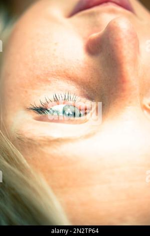 blonde young woman looking up, creative portrait Stock Photo