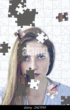 unfinished jigsaw puzzle with scattered pieces, of a woman face, psyche, psychology and shattered personal identity concept Stock Photo