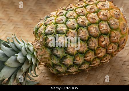 Single whole fresh ripe pineapple close up on a wicker background Stock Photo