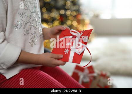 Little girl with gift from Christmas advent calendar at home, closeup Stock Photo