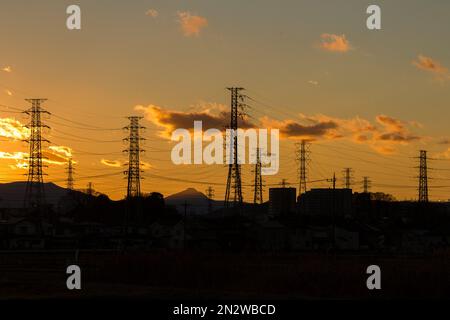 Electricity pylons against a sunset sky in rural Kanagawa, Japan. Stock Photo