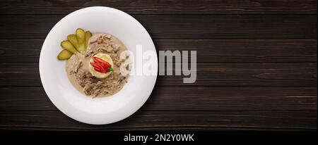 Mashed potatoes in mushroom sauce with mushrooms, on a wooden background. Banner Stock Photo