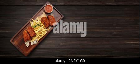 Barbecue ribs with french fries and barbecue sauce, on a wooden background. Banner Stock Photo