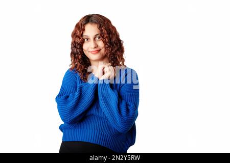 Portrait of woman wearing blue knitted sweater standing isolated over white background holding your hands looks hopefully at the camera, at you, and s Stock Photo