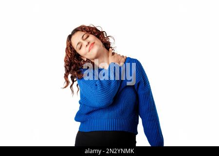 Millennial woman standing isolated over white background touching neck feeling pain and numbness, worried about muscle tension, osteochondrosis. Unhea Stock Photo