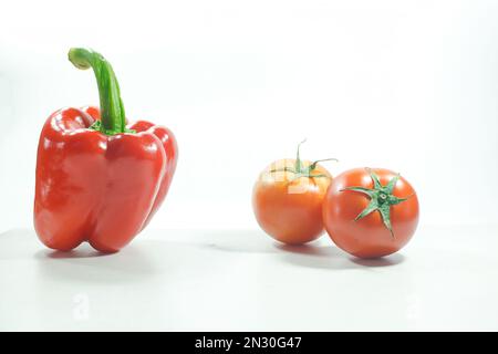 Red bell pepper , Red tomatoes on the White Blackground Used in cooking and eating fresh Stock Photo