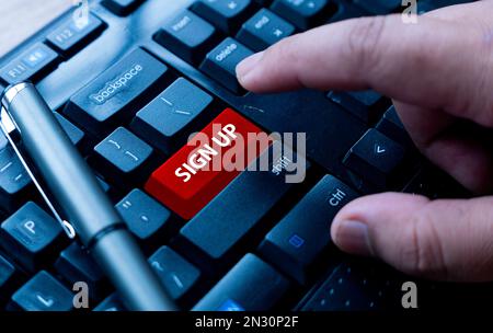 A finger pointing on a red computer keyboard written with Sign Up. Stock Photo