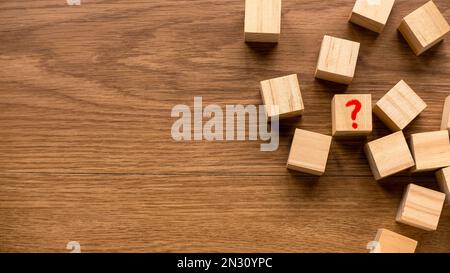 Top view of wooden cube written with Question symbol on wooden background. Stock Photo