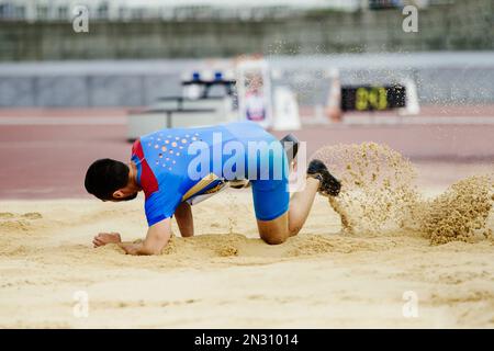 disabled athlete landing in sand long jump competition Stock Photo