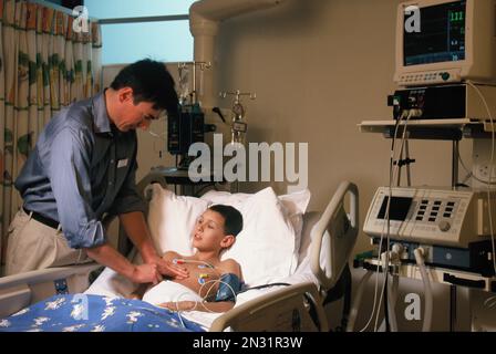 Surgeon with child patient in hospital intensive care ward. Stock Photo