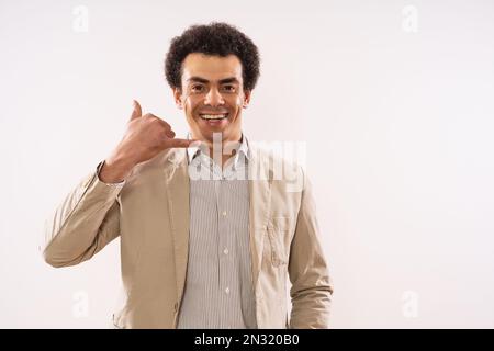 Portrait of happy and successful businessman showing call me gesture. Stock Photo