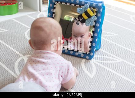 Baby looking in the mirror during tummy time Stock Photo