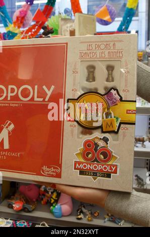 A saleswoman displays the new Monopoly board game version at a toy store near the Champs Elysees avenue in Paris, Wednesday, Feb. 4, 2015. The French version of Monopoly is celebrating its 80th year by slipping cash into 80 boxes of the game. One box will have the full complement in real money 20,580 euros ($23,600) as well as the Monopoly money needed to actually play the game, one of the most popular in France. 79 other boxes will have smaller amounts according to Hasbro. Sticker in the center reads, 'real money'. (AP Photo/Michel Euler)