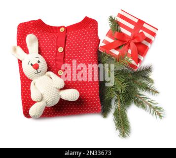 Red folded baby clothes and Christmas decorations on white background, top view Stock Photo