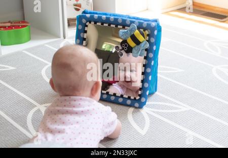 Baby looking in the mirror during tummy time Stock Photo