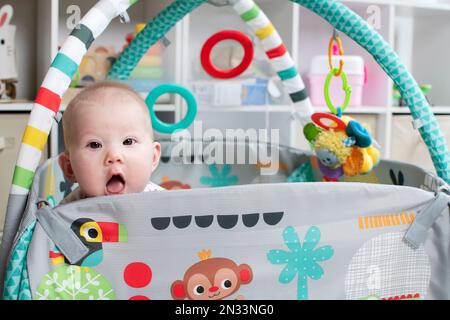 Cute caucasian baby girl on the play mat. Baby's first year Stock Photo