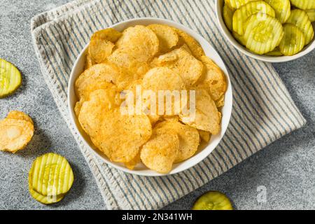 Homemade Flavored Dill Pickle Potato Chips in a Bowl to Eat Stock Photo
