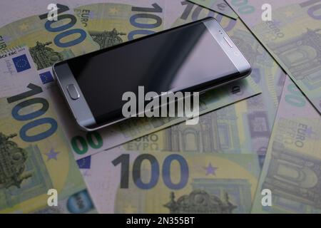 smartphone lies on 100 euro banknotes Stock Photo