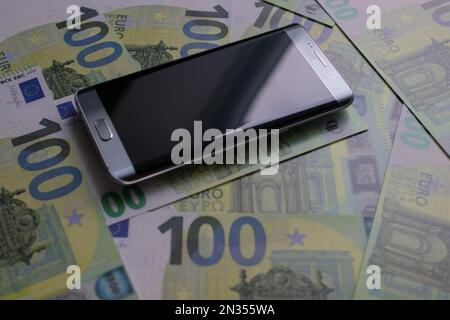 smartphone lies on 100 euro banknotes Stock Photo