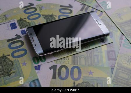 smartphone lies on 100 euro banknotes Stock Photo