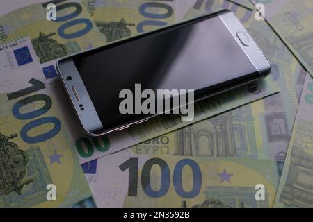 smartphone lies on 100 euro banknotes Stock Photo