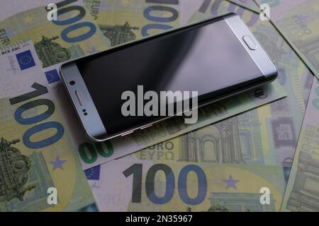 smartphone lies on 100 euro banknotes Stock Photo