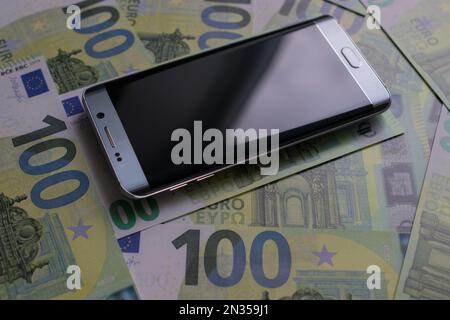 smartphone lies on 100 euro banknotes Stock Photo