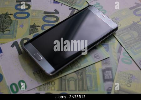 smartphone lies on 100 euro banknotes Stock Photo