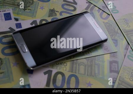 smartphone lies on 100 euro banknotes Stock Photo