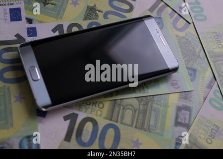 smartphone lies on 100 euro banknotes Stock Photo