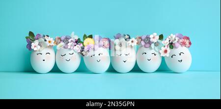 Funny Easter Eggs, hand drawn faces. Easter holiday concept with cute handmade eggs in floral wreath crowns Stock Photo