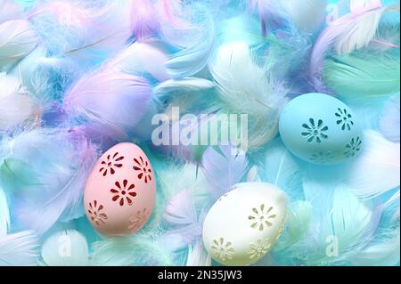 Easter background with feathers and eggs on blue background. Flat lay. Happy easter day card. Stock Photo