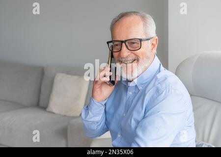 technology, people, lifestyle and communication concept - happy senior man dialing phone number and calling on smartphone at home Stock Photo