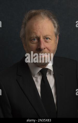 Head shot head and shoulders portrait of attractive mature senior older white man dressed in smart suit with collar and tie Stock Photo