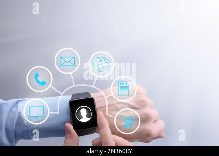 Smart watch on a businessman's hand. The guy chooses in the menu between different icons phone, sms, contacts, global network Stock Photo