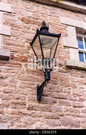 Old fashioned wrought iron and glass wall lamp, fited witth a modern COB LED bulb. Stock Photo