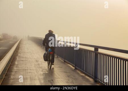 Belgrade, Serbia. October 25th, 2022. Man commuting on bicycle over urban structure. Stock Photo