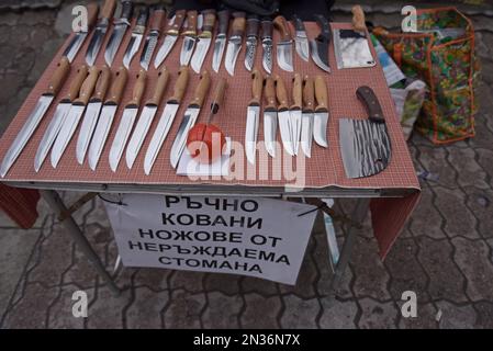 Hand forged craftsman made kitchen knives on sale at a street market stall in Velingrad, Bulgaria. Sign says "hand-forged knives of Non-Ferrous Steel" Stock Photo