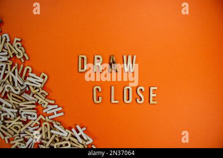 DRAW in wooden English language capital letters spilling from a pile of ...