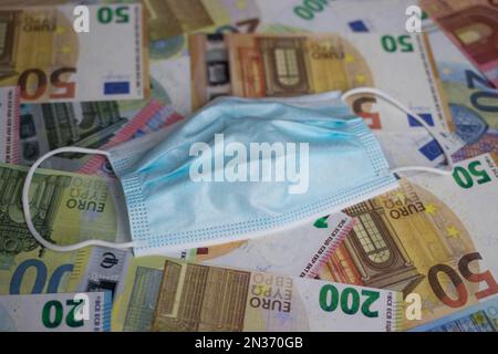 face mask lies on euro banknotes Stock Photo