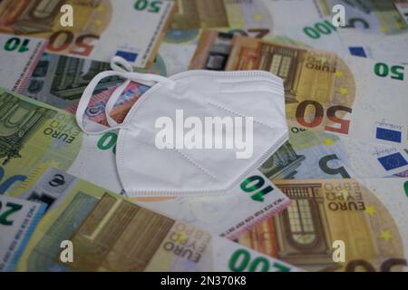 face mask lies on euro banknotes Stock Photo