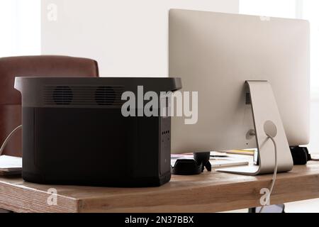 Portable power station on table in office Stock Photo