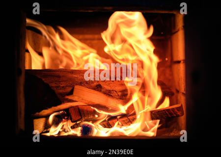 Wood on fire and live coals inside a wood-burning fireplace. Stock Photo